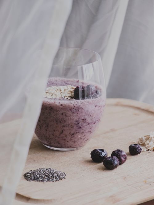 Free Delicious blueberry smoothie topped with oats and chia seeds for a nutritious breakfast. Stock Photo