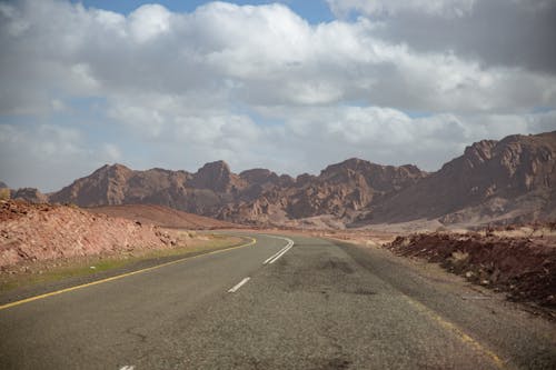 Free A Road Near the Brown Mountains Under White Clouds Stock Photo