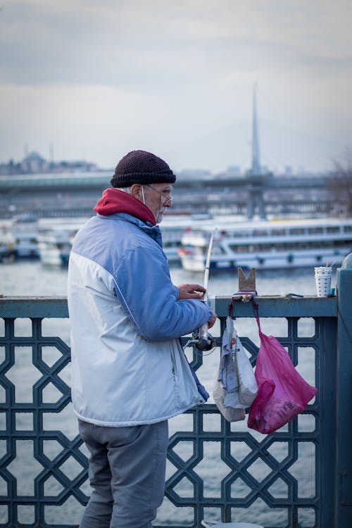 A Man wearing a Jacket while using Fishing Rod