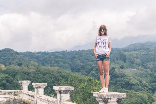 Woman Wearing White Shirt and Blue Denim Shorts Standing on Gray Concrete Stand
