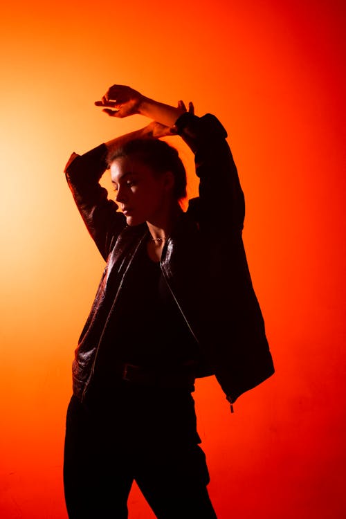 Woman Posing Arms Raised in Black Jacket