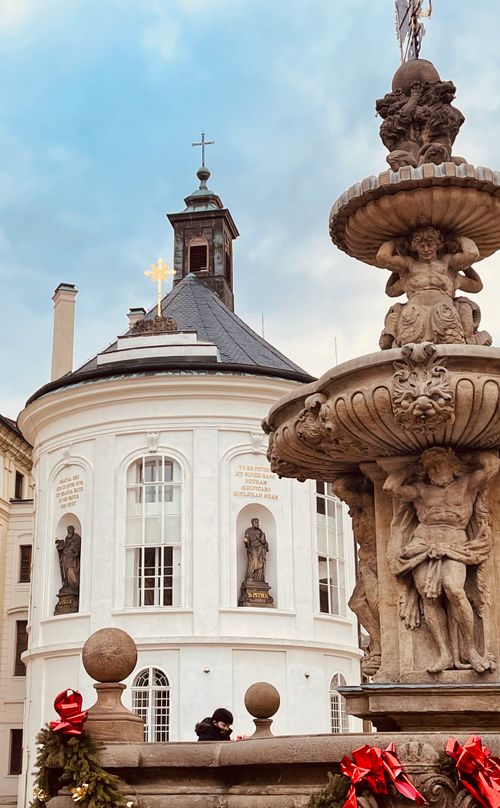 Free A captivating view of an ornate fountain beside a historic chapel in Prague, Czech Republic. Stock Photo