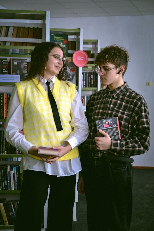 A Man and Woman Wearing Eyeglasses while Holding a Book