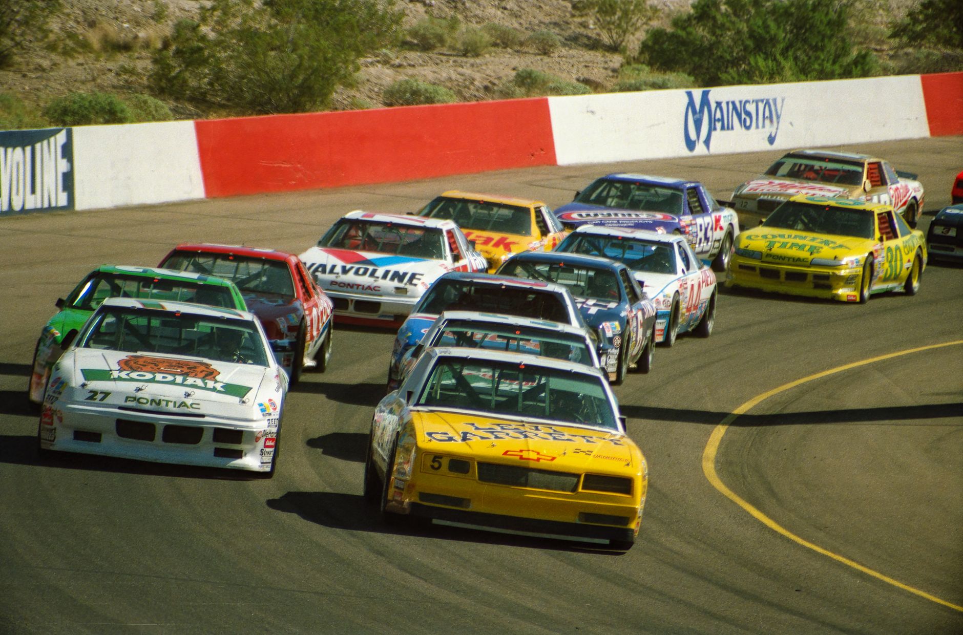 Exciting NASCAR race at Phoenix Raceway in Avondale, Arizona with colorful cars in action.
