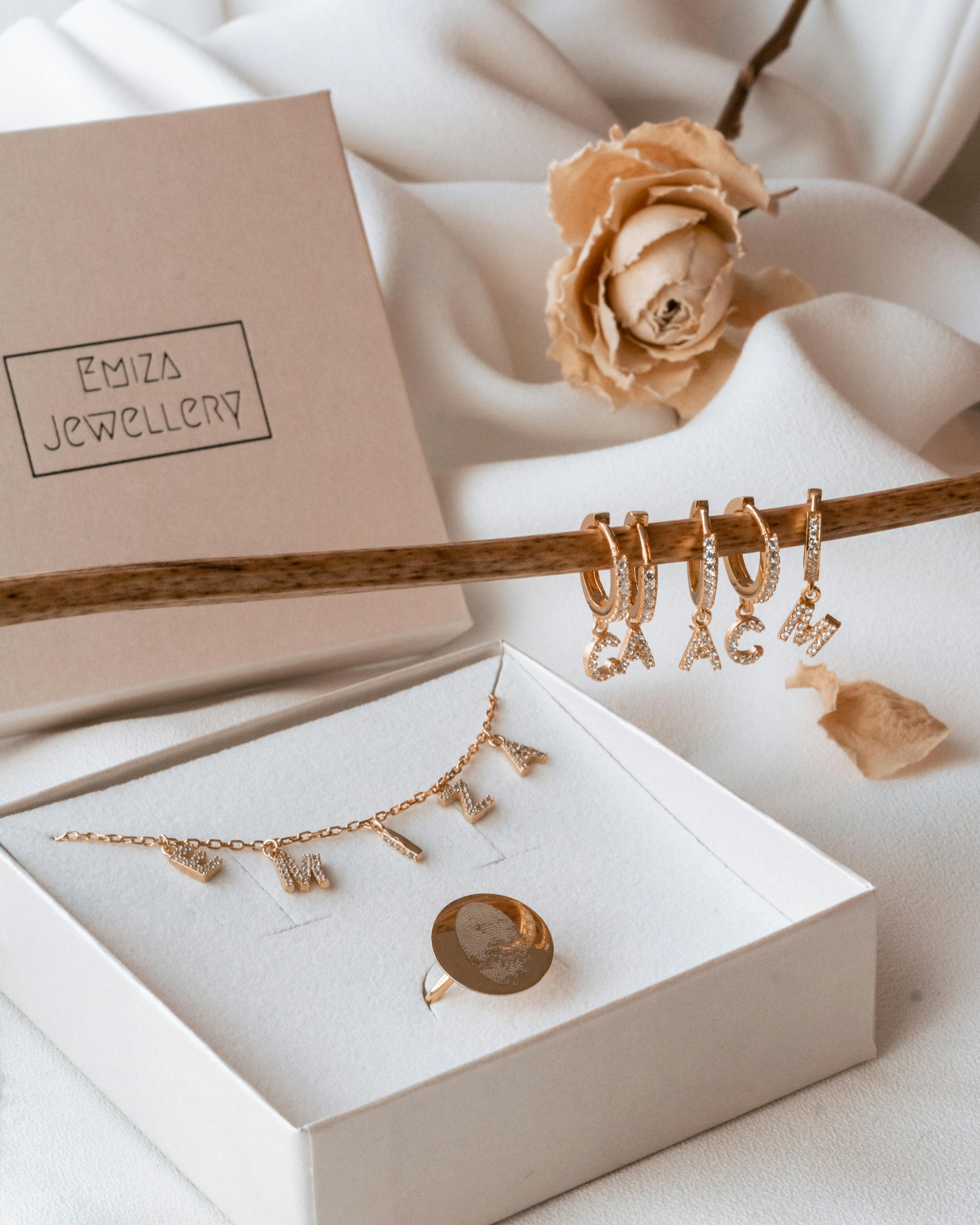 Stylish jewelry set with personalized letter charms displayed elegantly in a box.