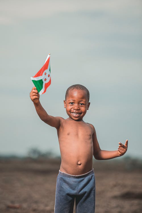 Topless Boy Holding a Burundi Flag