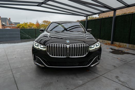 Front view of a shiny black luxury car parked in a modern covered garage setting.
