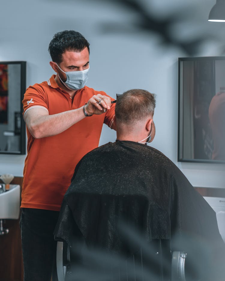 Barber Cutting The Hair Of A Man