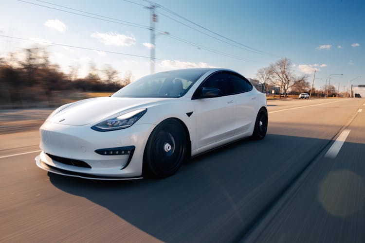 White Tesla Driving On The Road