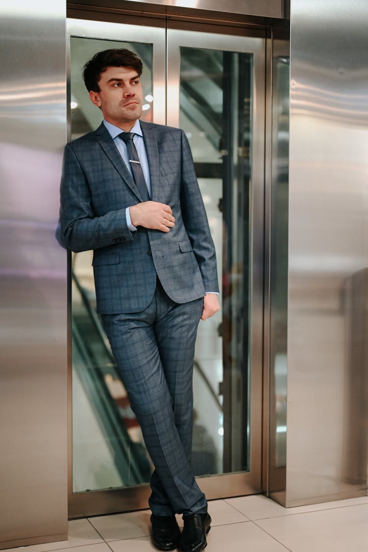 Man In Black Suit Standing In Front Of Elevator 