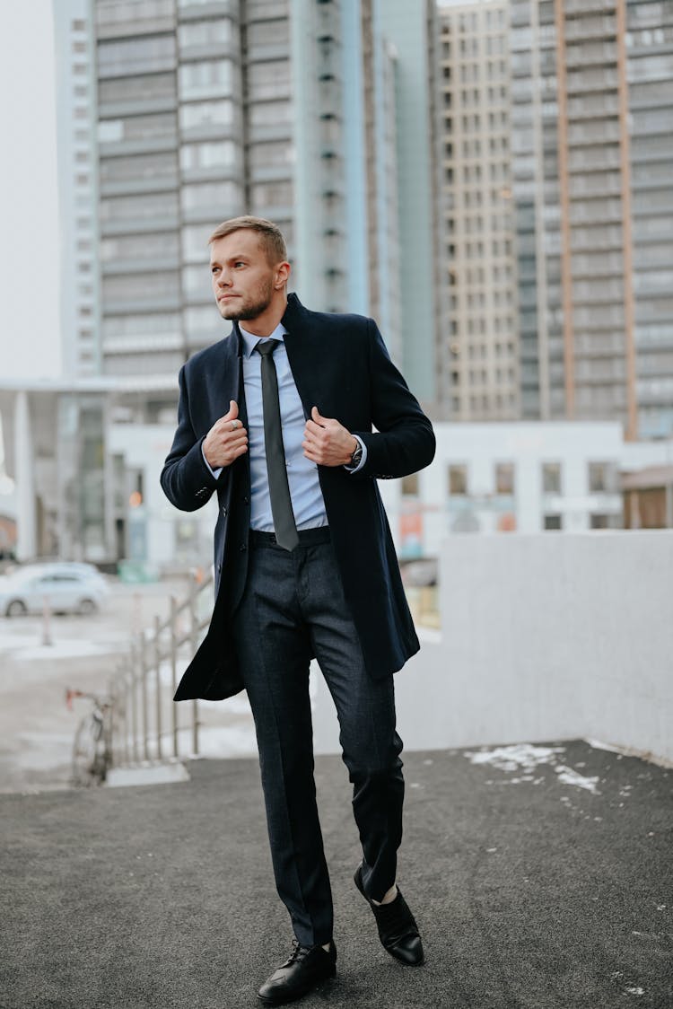 Man In Suit Fixing His Coat While Walking