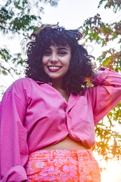 Smiling Woman in Pink Button-Up Shirt