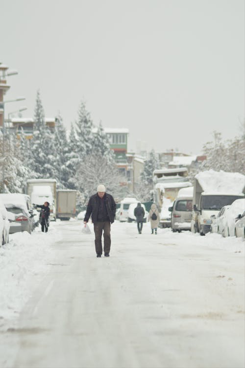 Man Walking on a Snow Covered Road