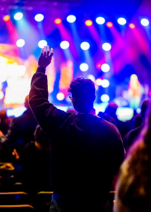 Man Raising his Hands While in a Concert
