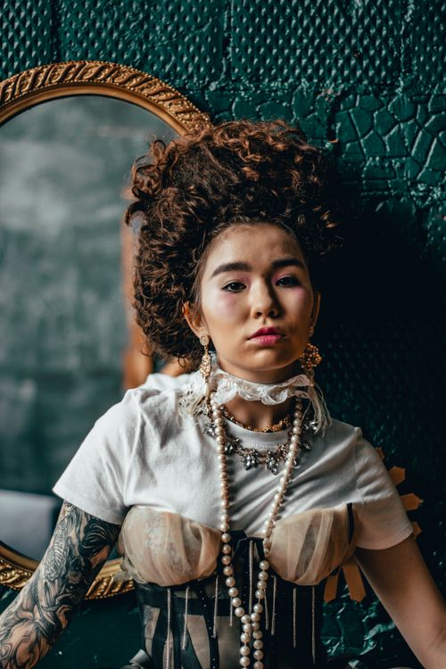 Free Elegant portrait of a woman in vintage fashion with pearl necklaces and bold accessories Stock Photo