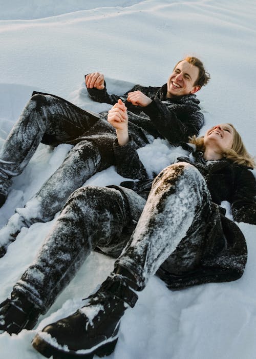 A Couple Lying on a Snow Covered Ground