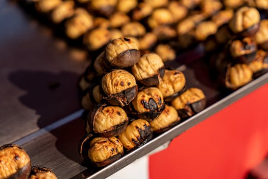Close-up of roasted chestnuts on a metal tray, highlighting texture and color.