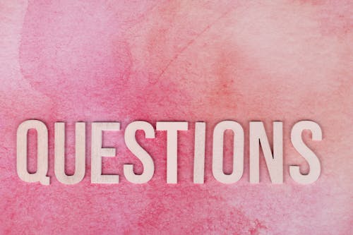 Free Questions Text on a Pink Surface Stock Photo