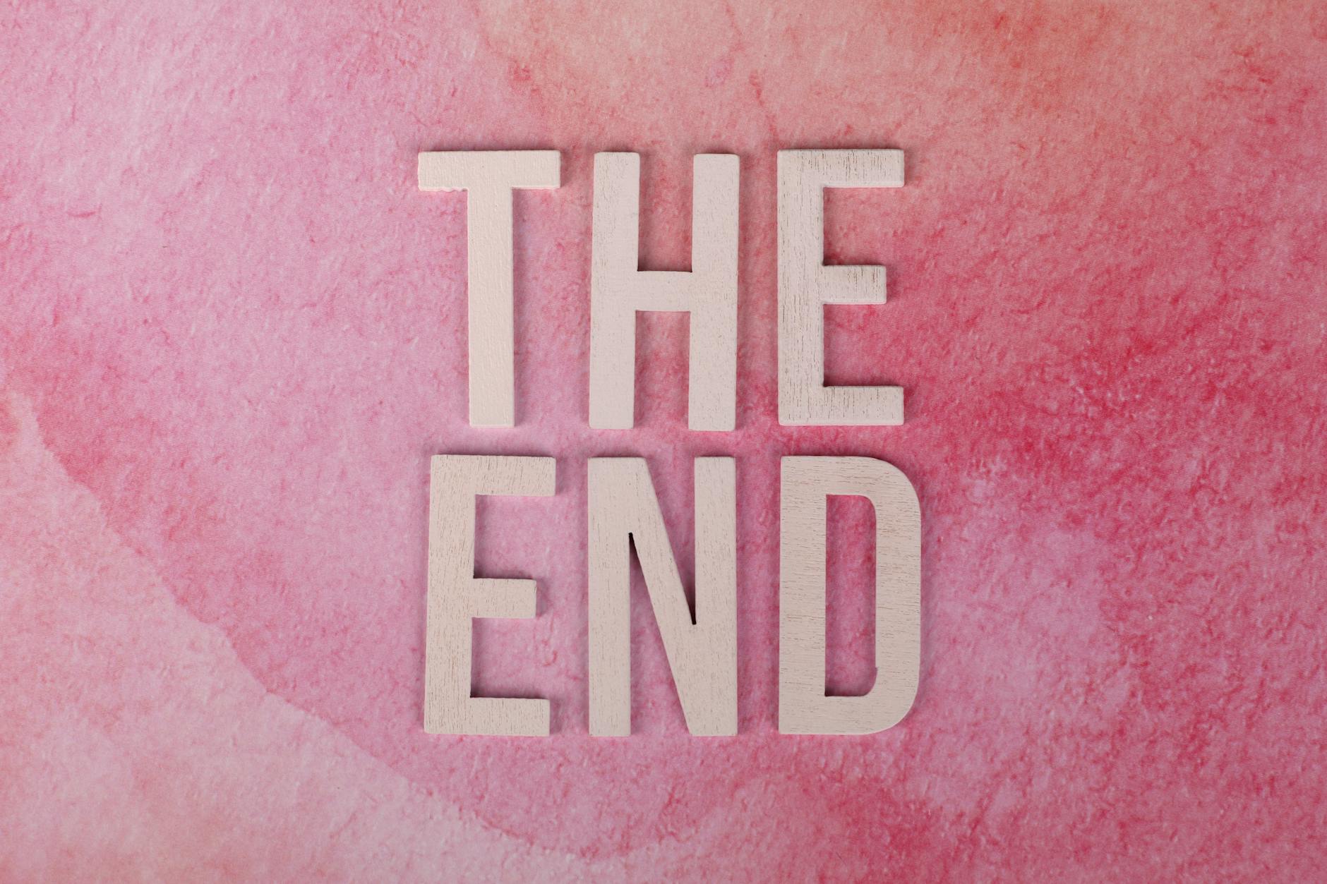 Elegant 'The End' text on a textured pink background, perfect for closure or transition concepts.