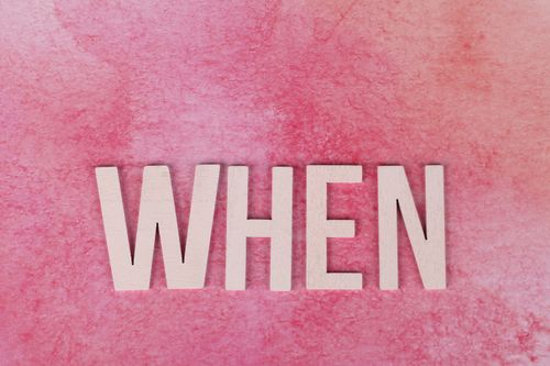 Free The word 'WHEN' in white letters displayed on a pink watercolor textured background, perfect for design projects. Stock Photo