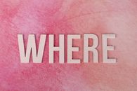 The word WHERE in bold wooden letters on a vibrant pink textured background, offering copyspace.