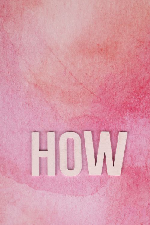Free Creative pink watercolor background texture with the word 'HOW' in bold letters. Stock Photo