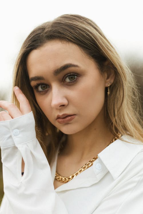 Young Blond Woman with Brown Eyes in White Shirt