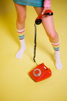 Colorful retro-themed image featuring a red rotary phone and striped socks on a yellow background.