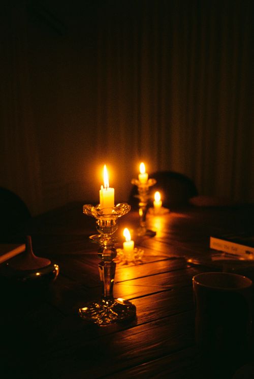 Free A warmly illuminated dining room set with lit candles creating a cozy, mysterious atmosphere. Stock Photo