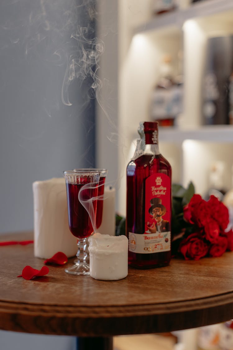 A Bottle And Glasses Of Cherry Tincture Wine On The Table