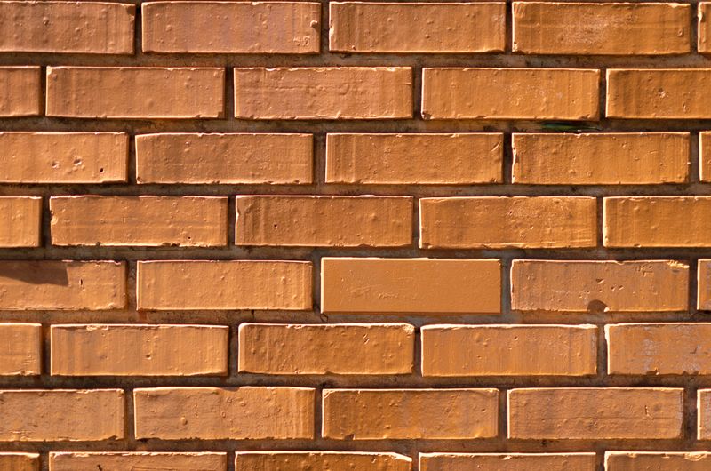 Warm clay brick wall texture in natural light