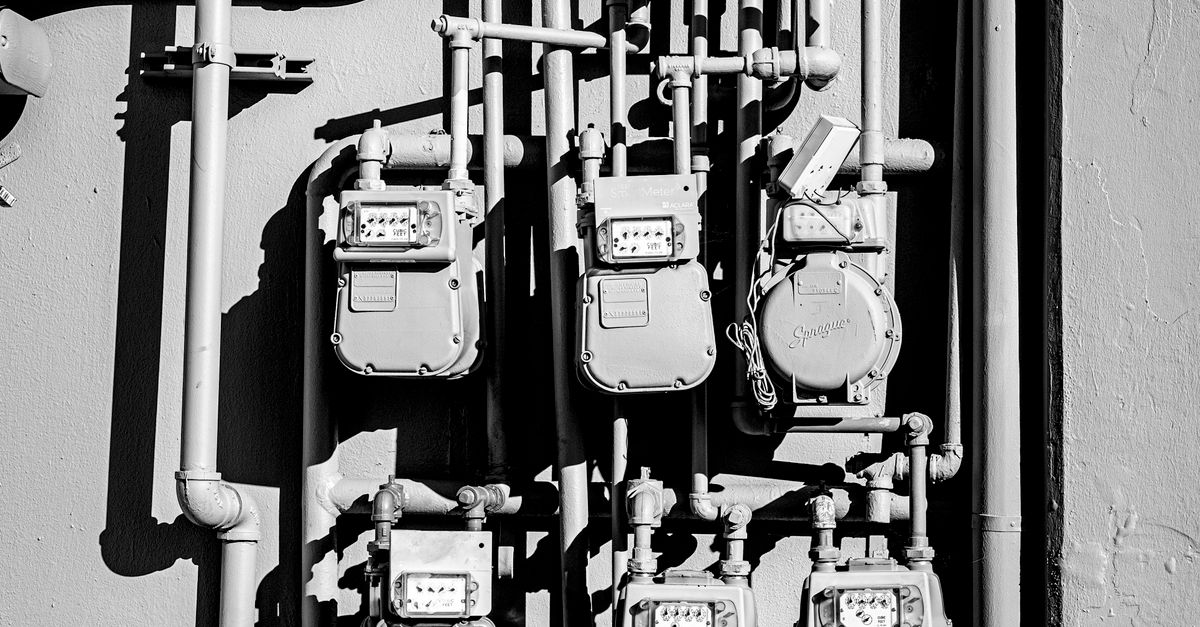Electric meters and conduit pipes on an industrial wall