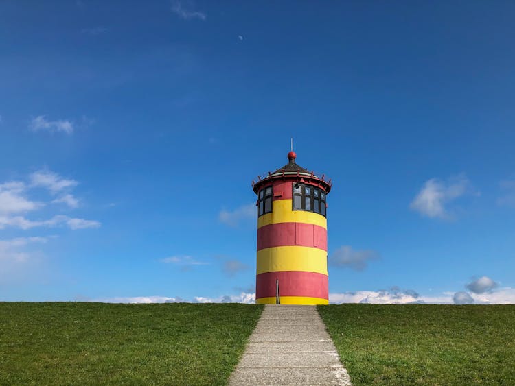 Red And Yellow Light House Under Blue Sky