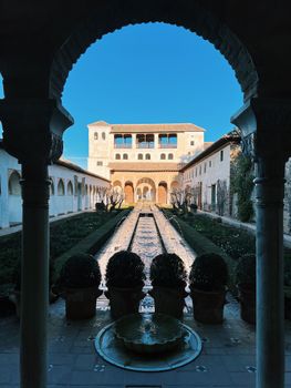 Beautiful view of the Alhambra's Generalife gardens in Granada, Spain, under a clear blue sky.