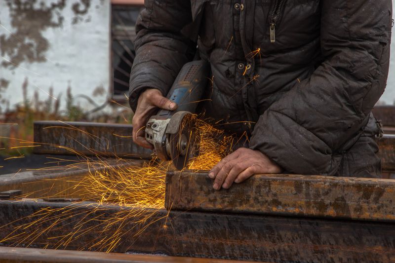 Grinder throwing sparks on steel beams