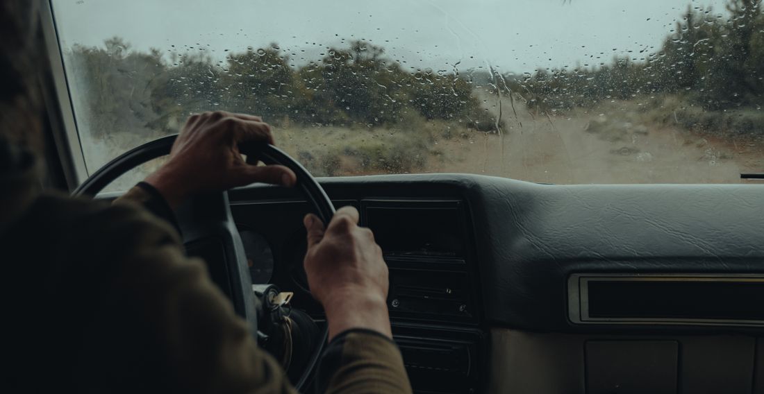 View from inside vehicle driving off-road on rainy day
