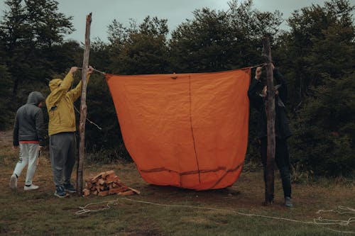 Campers Setting Up an Orange Tent