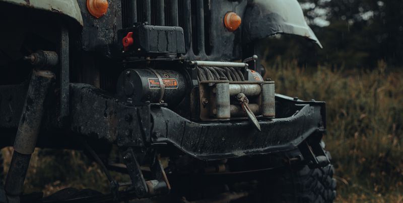 Recovery truck pulling a vehicle from muddy terrain