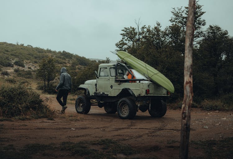 Kayak Strapped To The Back Of Car And Man Walking