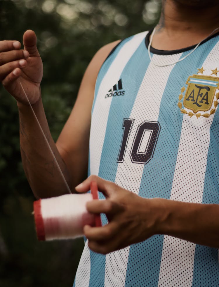 A Person Holding A Roll Of Nylon String