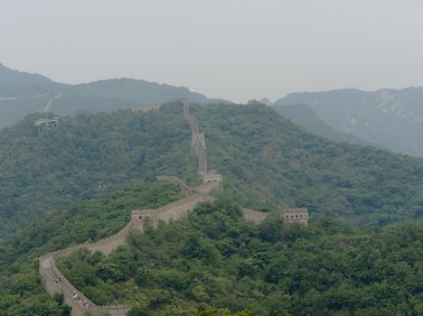 Stunning aerial view of the Great Wall of China surrounded by lush green hills.