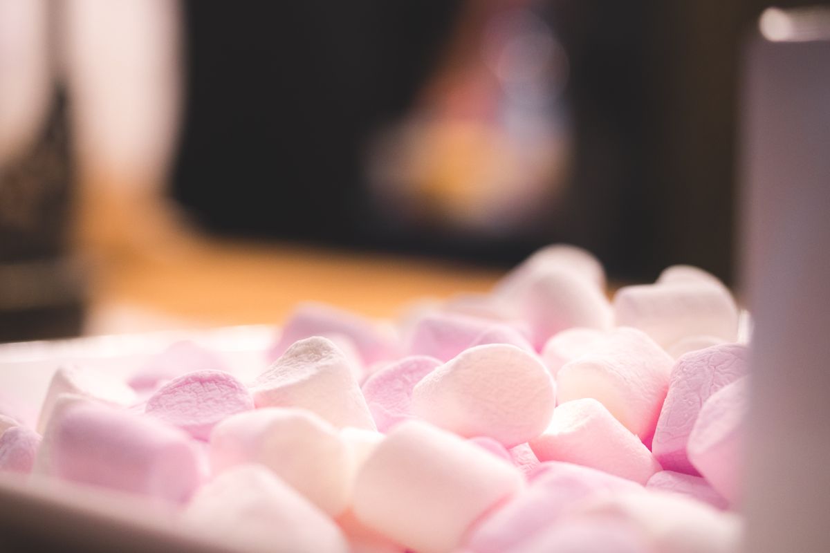Delightful close-up of pink and white marshmallows in warm lighting, perfect for sweet treat themes.
