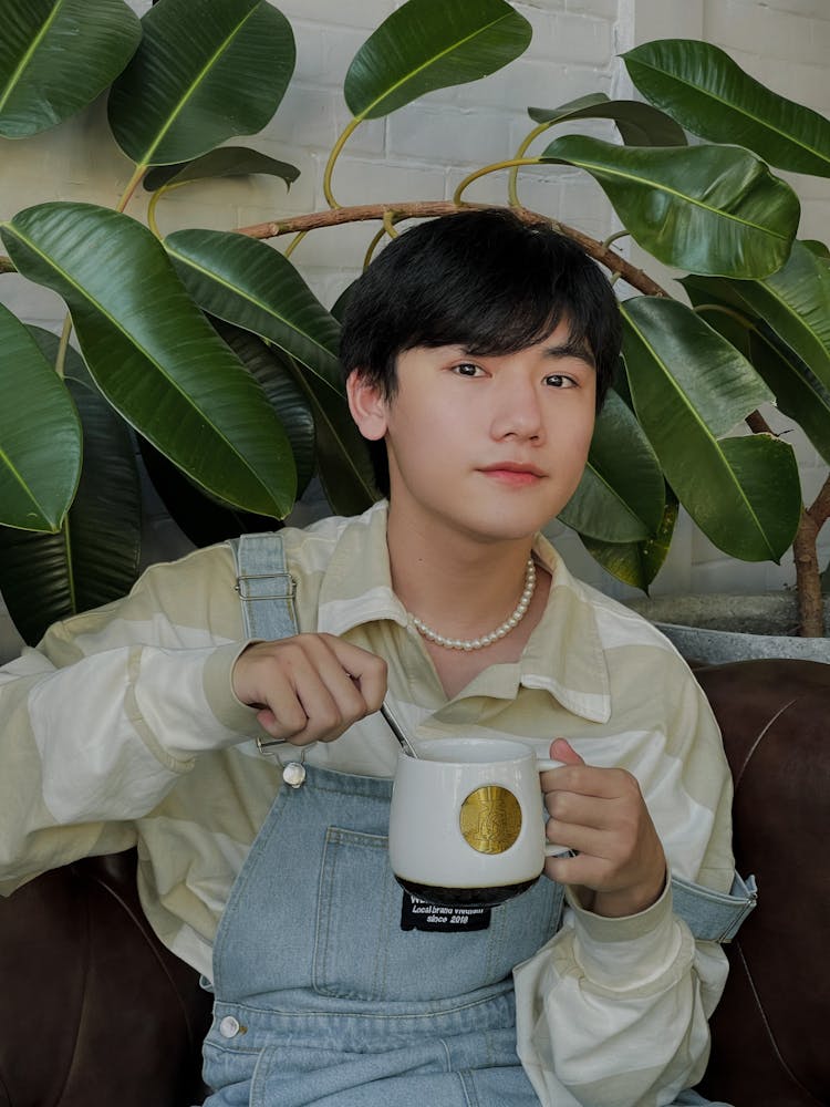 Photo Of A Boy Holding A White And Gold Mug