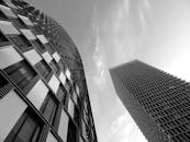 这幅引人注目的黑白图像，展现了现代摩天大楼的未来派建筑风格与城市优雅