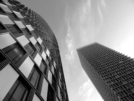 这幅引人注目的黑白图像，展现了现代摩天大楼的未来派建筑风格与城市优雅