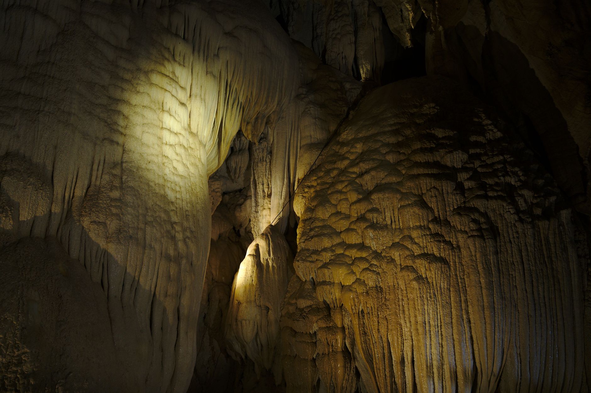A stunning view of stalactites and cave formations lit with natural lighting.