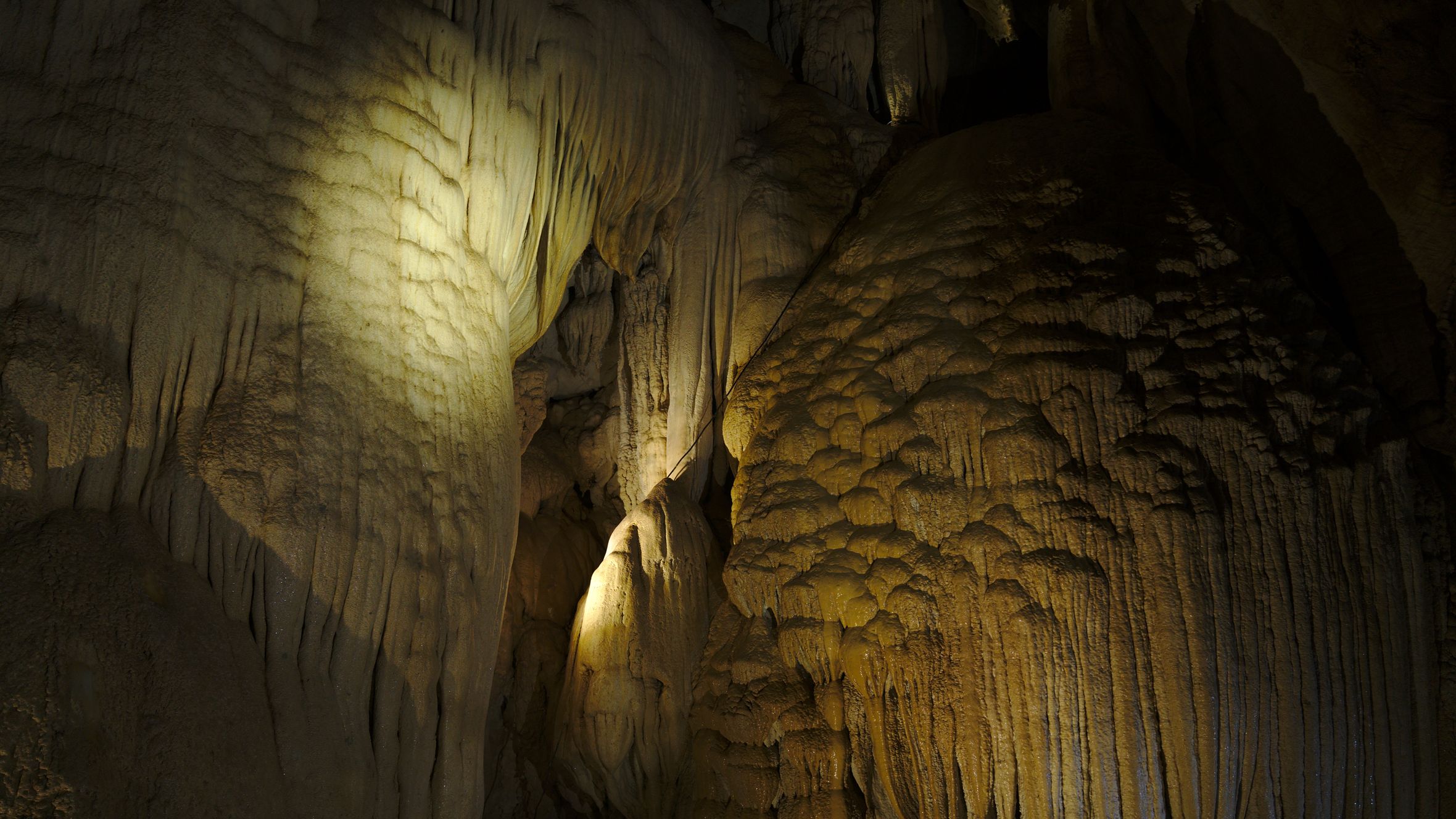 A stunning view of stalactites and cave formations lit with natural lighting.