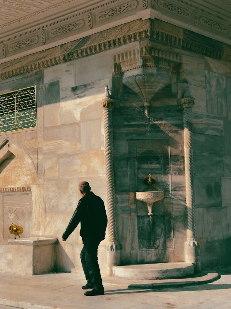 Man Walking By Public Water Fountain