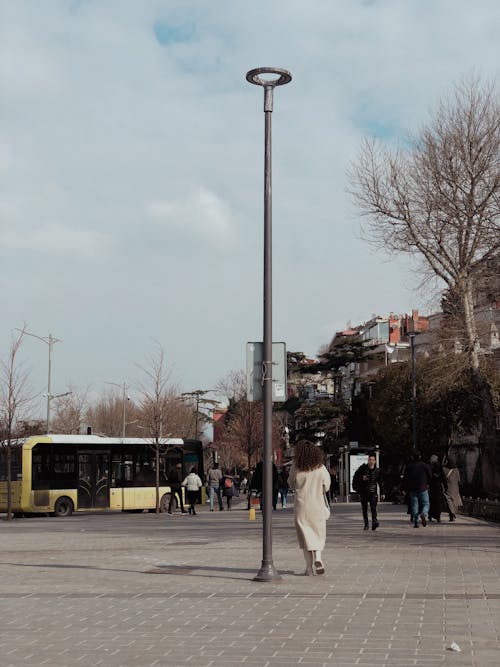 People Walking on Sidewalk Near Yellow Bus