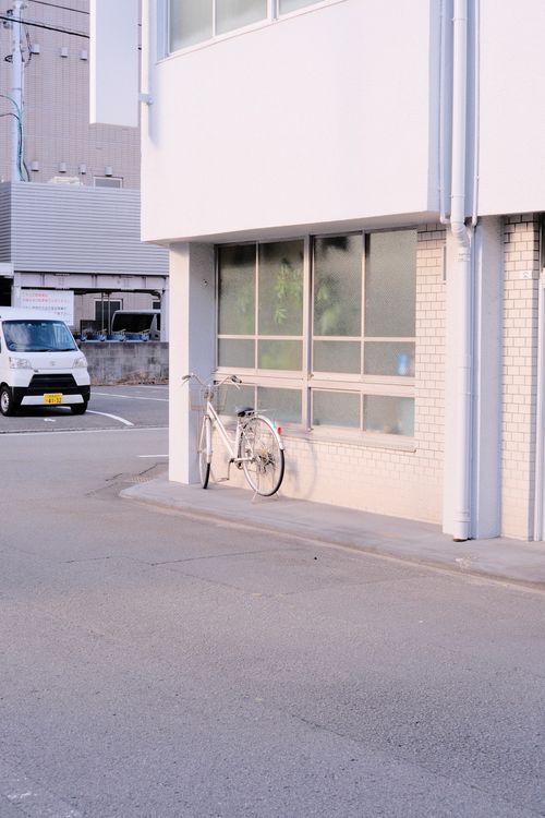 Free A tranquil urban street corner with a bicycle against a building, early day. Stock Photo